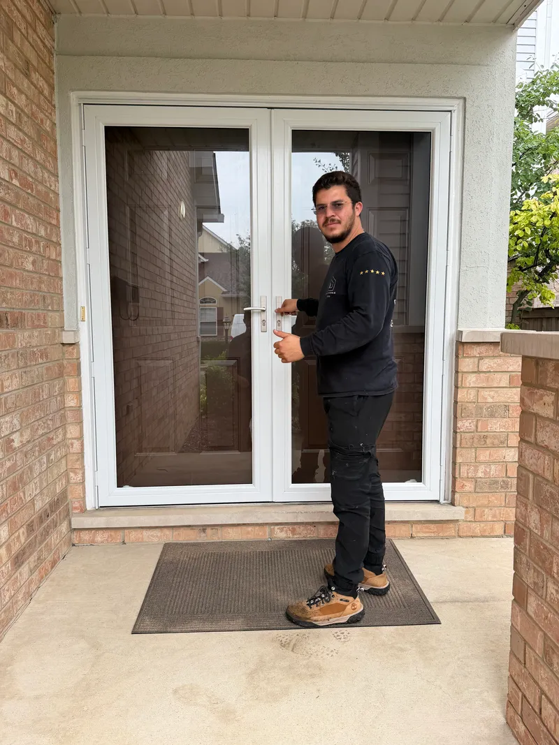 Diego Ivan checking the handle on a white patio door
