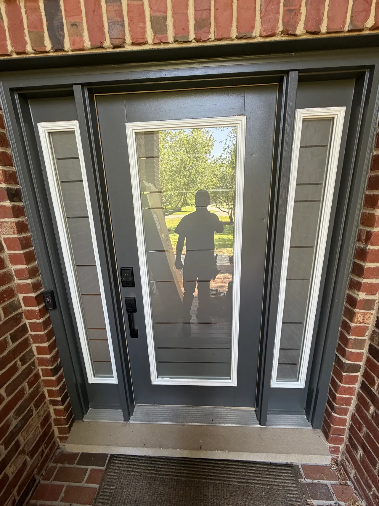 Finished dark entry door with sidelights and horizontal frosted glass